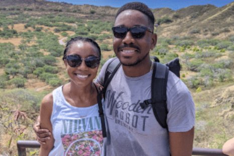 Samuel and Oneisha smiling in sunglasses on a hike